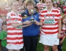 County Antrim Camogie Treasurer Margaret Flynn presents the Junior Camogie Championship Trophy to Breige Ferry and Grainne Kerr of St.Pauls